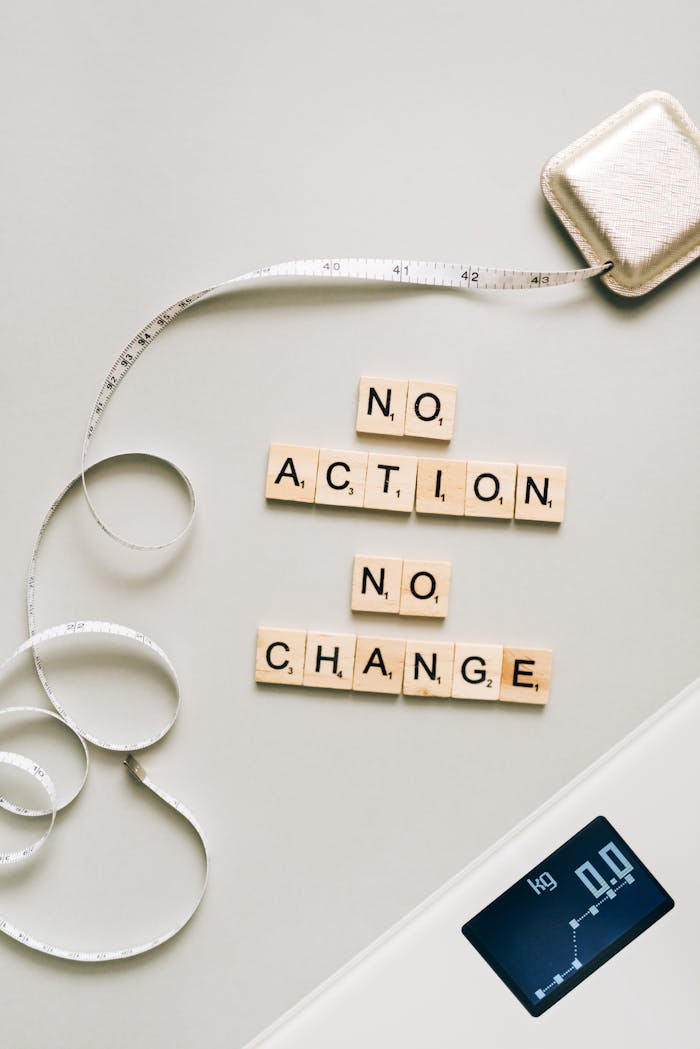 Letter tiles forming a motivational message alongside a scale and measuring tape.