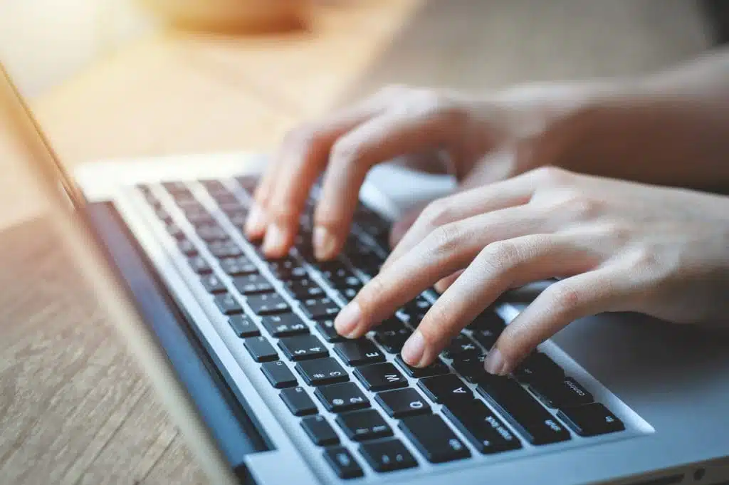 Close up of female hands while typing on a laptop keyboard. business or student using laptop at home, online learning, internet marketing, working from home, office workplace, freelance concept